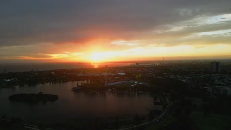 Aerial-drone-view-of-a-moody-sunset-in-Albert-Park-and-Lake,-Melbourne,-Australia