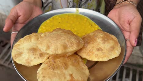 Profile-view-of-luchi-and-cholar-dal-served-by-roadside-stall-in-Kolkata,-India