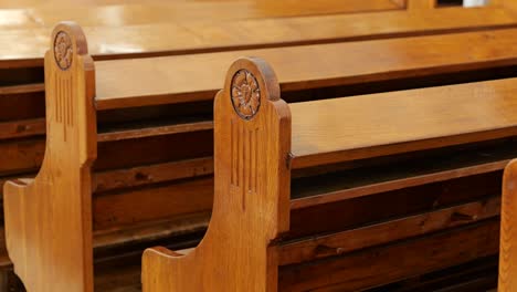 Slow-track-along-rows-of-vintage-wooden-pews-in-Lutheran-church