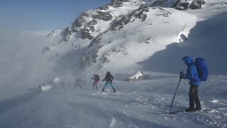 Skiers-start-descent-down-ski-run-in-Voss,-Norway-amidst-blowing,-powdery-snow