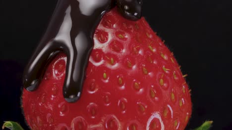 El-Rico-Líquido-De-Chocolate-Se-Vierte-Sobre-Las-Suculentas-Fresas,-Sobre-Un-Fondo-Negro,-Que-Encarna-El-Concepto-De-Deliciosos-Postres-De-Frutas.