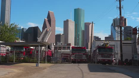 Tomas-De-Un-Patio-Lleno-De-Camiones-De-Bomberos-Discapacitados-Con-El-Centro-De-Houston-Al-Fondo