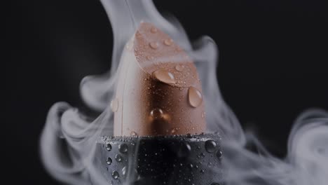 A-close-up-captures-lipstick-enveloped-in-billowing-white-smoke-against-a-black-backdrop,-symbolizing-the-allure-and-mystery-of-makeup