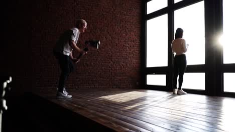 Freelance-video-production-session,-model-stand-near-bright-studio-window