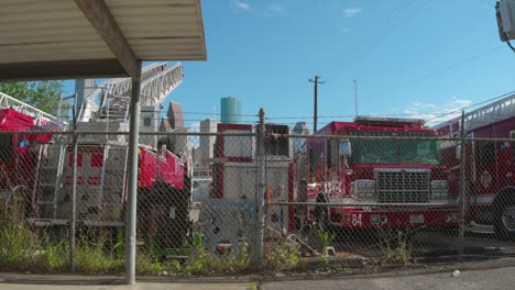 Toma-De-Escena-De-Un-Patio-Lleno-De-Camiones-De-Bomberos-Discapacitados-Con-El-Centro-De-Houston-Al-Fondo