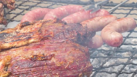 Blick-Auf-Das-Grillen-Von-Fleisch-Auf-Einem-Grill,-Während-Einige-Würstchen-Gewendet-Werden