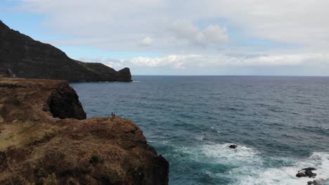 El-Dron-Captura-Una-Majestuosa-Formación-Rocosa-En-La-Isla-De-Madeira,-Donde-Se-Encuentran-Dos-Figuras,-Eclipsadas-Por-El-Paisaje-Accidentado,-Resaltando-La-Grandeza-De-La-Naturaleza.