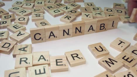 Finger-Der-Rechten-Hand-Bilden-Das-Wort-Cannabis-Mit-Scrabble-Buchstabensteinen
