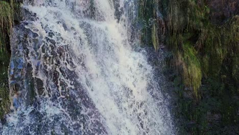 Aerial-drone-footage-of-a-tall-rocky-waterfall-in-the-Yorkshire-Dales,-Pennies