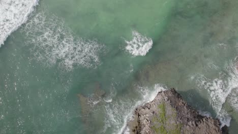 Drone-video-flying-over-small-Island,-water-waves-in-Coastal-Kenya