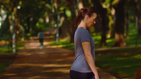 Woman-wearing-sportswear-outdoors,-shade-of-trees,-exercising,-slow-mo