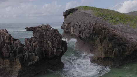 Close-up-reveal-drone-shot-of-Island-rock-face