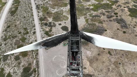 Extreme-close-up-aerial-view-of-a-wind-turbine-destroyed-by-a-fire-in-a-arid-landscape-in-SE-Spain