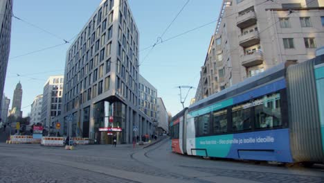 Clean-and-shiny-street-car-tram-follows-tracks-on-Helsinki-city-street