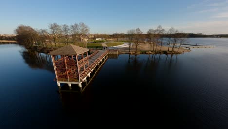 FPV-Drohnenaufnahme-über-Einem-Pier-Und-Menschen,-Frühlingssonnenuntergang-In-Masuren,-Polen