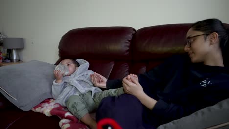 Mother-Tickling-Foot-Of-Her-Son-Drinking-Milk-On-The-Sofa