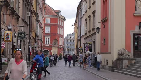 La-Zona-Peatonal-Del-Casco-Antiguo-De-Varsovia,-En-Polonia,-Está-Repleta-De-Visitantes-Y-De-Una-Actividad-Bulliciosa,-Que-Personifica-El-Espíritu-De-Viaje-Y-Exploración.