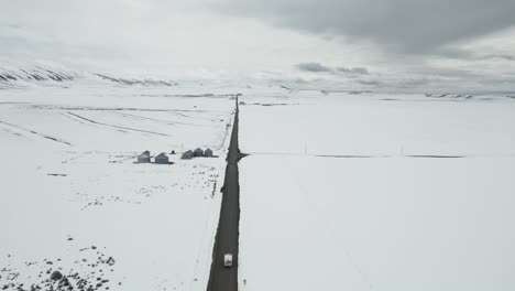 Luftaufnahme-Eines-Weißen-Wohnmobils,-Das-Eine-Winterliche,-öde-Landschaft-In-Idaho,-USA-Durchquert