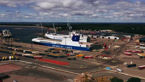 Aerial-ascending-shot-of-cargo-ships-at-a-shipping-harbor,-in-sunny-Hanko,-Finland