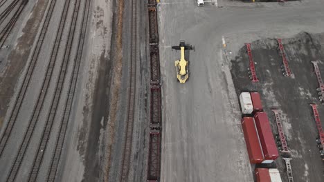 mobile-crane-driving-inside-the-Canadian-National-Railway-St-Laurent-Montreal-Quebec-Canada-with-cargo-shipping-container-parked