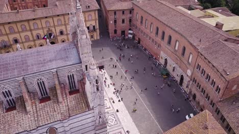 Aerial-top-down-of-Siena-historical-downtown-city-center-with-tourist-gathering-on-main-cathedral-Duomo-square-,-medieval-town-village-in-Tuscany-Italy-travel-holiday-destination
