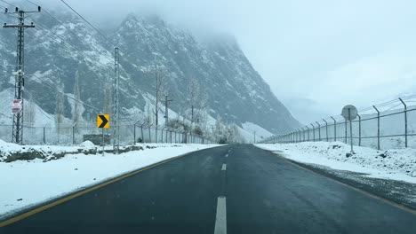 Coche-Conduciendo-Por-Una-Carretera-En-Skardu-En-Un-Paisaje-Cubierto-De-Nieve-Y-Altas-Montañas