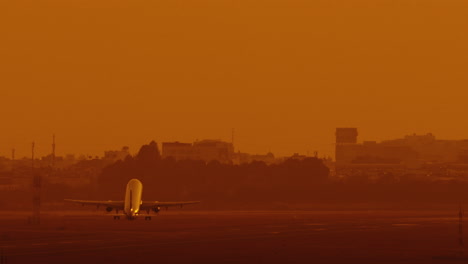 passenger-airplane-taking-off-fro-runaway-airstrip-at-sunset-,-slow-motion-of-jet-plane-up-in-the-sky