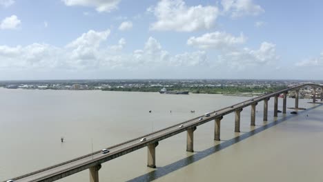 Wide-angle-aerial-shot-of-Jules-Wijdenbosch-Bridge-between-Paramaribo-and-Meerzorg-in-Suriname,-South-America,-with-traffic-as-drone-flies-over-bridge