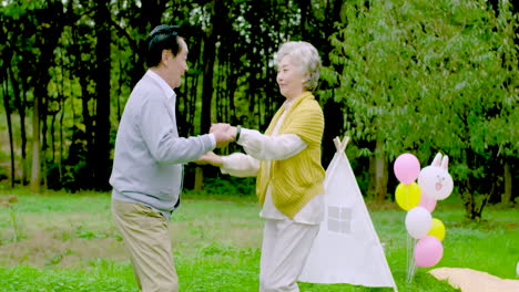 Positives-älteres-Familienpaar,-Das-Im-Grünen-Park-Tanzt,-Lächelnde,-Glückliche-Rentner,-Glückliches,-Schönes,-Fröhliches,-Aktives-Rentnerpaar,-Freizeit-Der-Großeltern