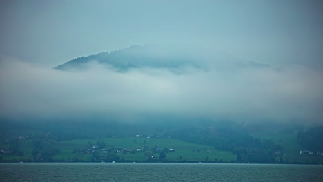Mountain-Settlements-Engulfing-Foggy-Clouds-By-The-Shore-Of-Attersee-Lake-In-Salzkammergut,-Austrian-State-Of-Upper-Austria