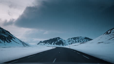 POV-driving-video-through-Northern-Iceland's-snowy-landscape-at-sunset,-capturing-serene-winter-beauty-and-soft-lighting