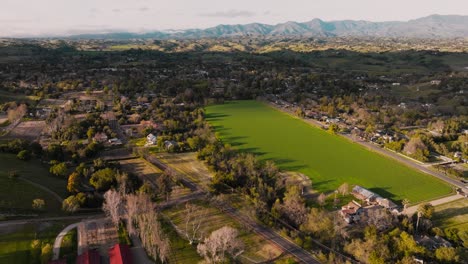 Luftaufnahmen-über-Felder-Und-Häuser-Im-Malerischen-Santa-Ynez,-Kalifornien,-Ländliche-Gegend-An-Der-Zentralküste-Mit-Bergen-Am-Horizont