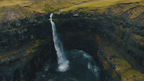 Mulafossur-waterfall,-Faroe-Islands:-fantastic-aerial-view-in-orbit-and-in-the-middle-distance-of-the-beautiful-waterfall-and-the-wind-hitting-the-water