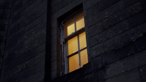 Low-angle-view-looking-into-the-window-at-night,-stalking-in-urban-environment