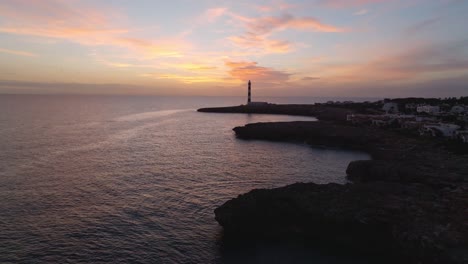 Puesta-De-Sol-De-Drones-Aéreos-Brillando-En-El-Paisaje-De-Playa-De-La-Isla-De-Menorca-Fondo-De-Faro-Degradado-Rosa-En-Destino-De-Viaje-Español