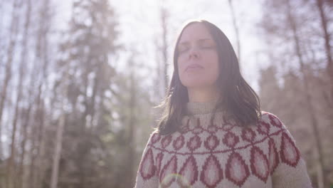 Woman-meditating-outdoors-shrugs-to-release-tension-in-shoulders,-front-high-key