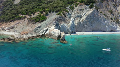 Aerial:-Slow-orbit-shot-of-the-limestone-arch-rock-formation-in-Lalaria-beach-in-Skiathos-island,-Sporades,-Greece-on-a-sunny-day