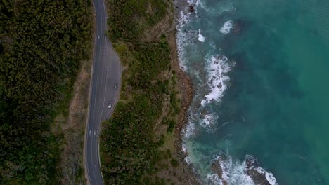 Top-down-drone-view-of-cars-parked-at-Great-Ocean-Road-lookout-with-ocean-waves,-Victoria,-Australia