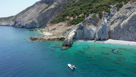 Aerial:-Slow-orbit-shot-of-Lalaria-beach-in-Skiathos-island,-Sporades,-Greece-with-turquoise-and-emerald-crystal-clear-water