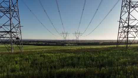 Toma-Baja-De-Un-Dron-Entre-Enormes-Líneas-Eléctricas-Al-Atardecer