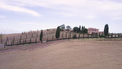 Moderno-Automóvil-Descapotable-Conduciendo-En-La-Carretera-Rural-Cypress-Hill-En-Toscana-Imágenes-Aéreas-De-Drones