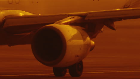 Primer-Plano-Del-Motor-Bajo-El-Ala-Del-Avión-De-Pasajeros-En-La-Pista-De-Aterrizaje-En-Cámara-Lenta
