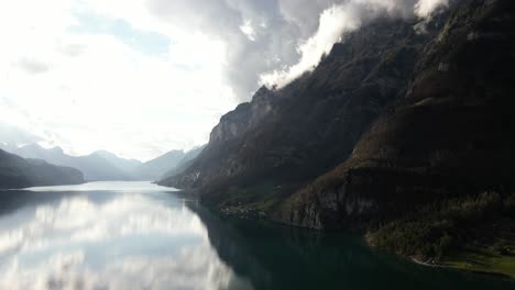 Montañas-Rocosas-Y-Nubes-Reflejadas-En-La-Superficie-Del-Lago-Walensee-Unterterzen-En-Suiza