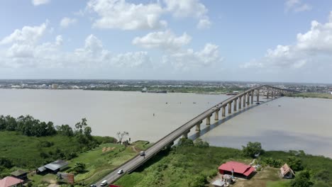 Wide-angle-aerial-shot-of-Jules-Wijdenbosch-Bridge-between-Paramaribo-and-Meerzorg-in-Suriname,-South-America,-with-traffic-as-drone-orbits-around-bridge