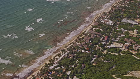 Tulum-Mexico-Aerial-v22-zoom-birds-eye-view-drone-flyover-resort-town-along-sandy-beach-of-the-Caribbean-coast-capturing-tranquil-waves-crashing-onto-the-shore---Shot-with-Mavic-3-Pro-Cine---July-2023