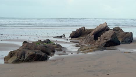 Spain's-rough-and-rocky-coastline-is-bordered-by-crashing-ocean-waves-in-the-distance,-capturing-a-tranquil-daytime-vista-of-natural-splendor