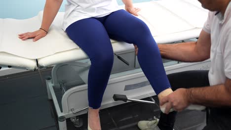 Männlicher-Physiotherapeut-Beurteilt-Die-Bein--Und-Kniebeweglichkeit-Einer-Patientin