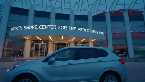 Cars-driving-in-front-of-North-Shore-Center-for-the-Performing-Arts-in-Skokie,-Illinois,-USA