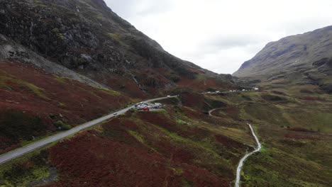 Toma-Aérea-Descendente-De-La-Carretera-A82-Que-Pasa-Por-Las-Montañas-Gencoe-Escocia-Reino-Unido