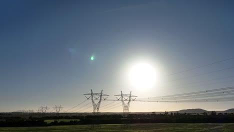 Drone-pushing-towards-powerlines-catches-sun-flare